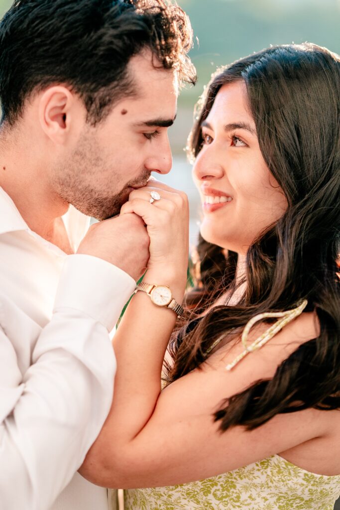A close up of a man kissing his partner on the hand showing off her large engagement ring in a portrait by a Northern VA wedding photographer