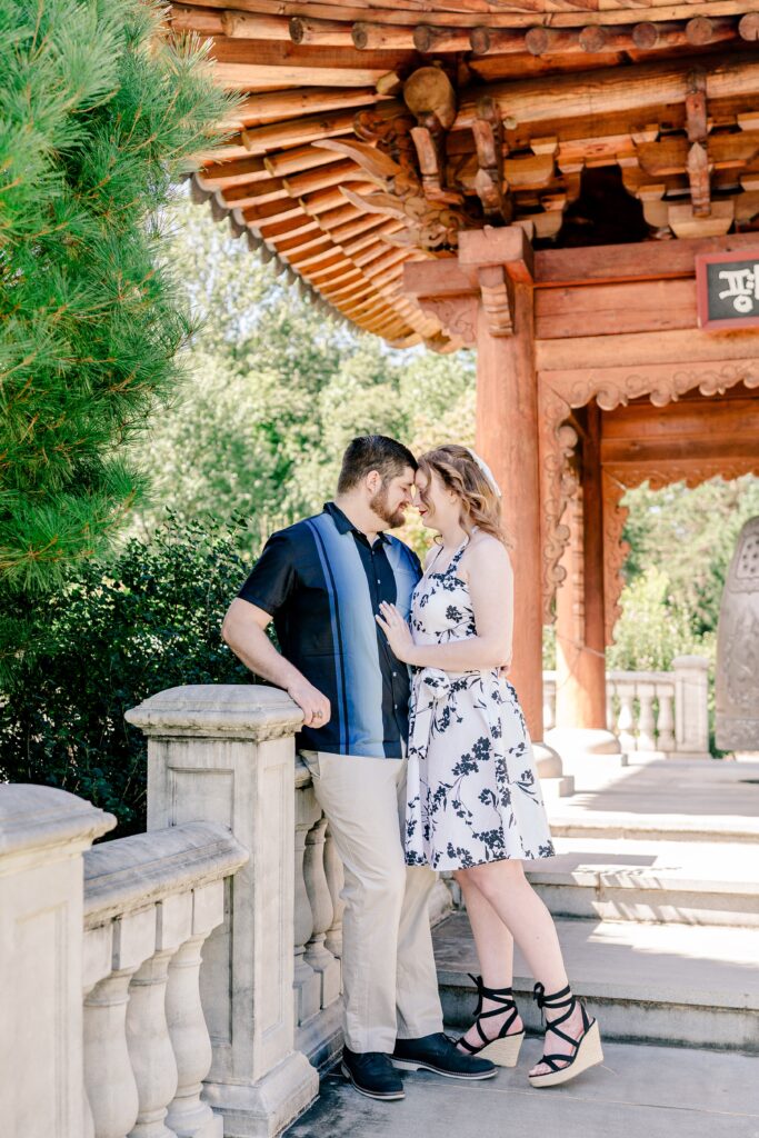 An engaged couple nuzzles close together on a staircase during their Meadowlark Botanical Gardens engagement photos