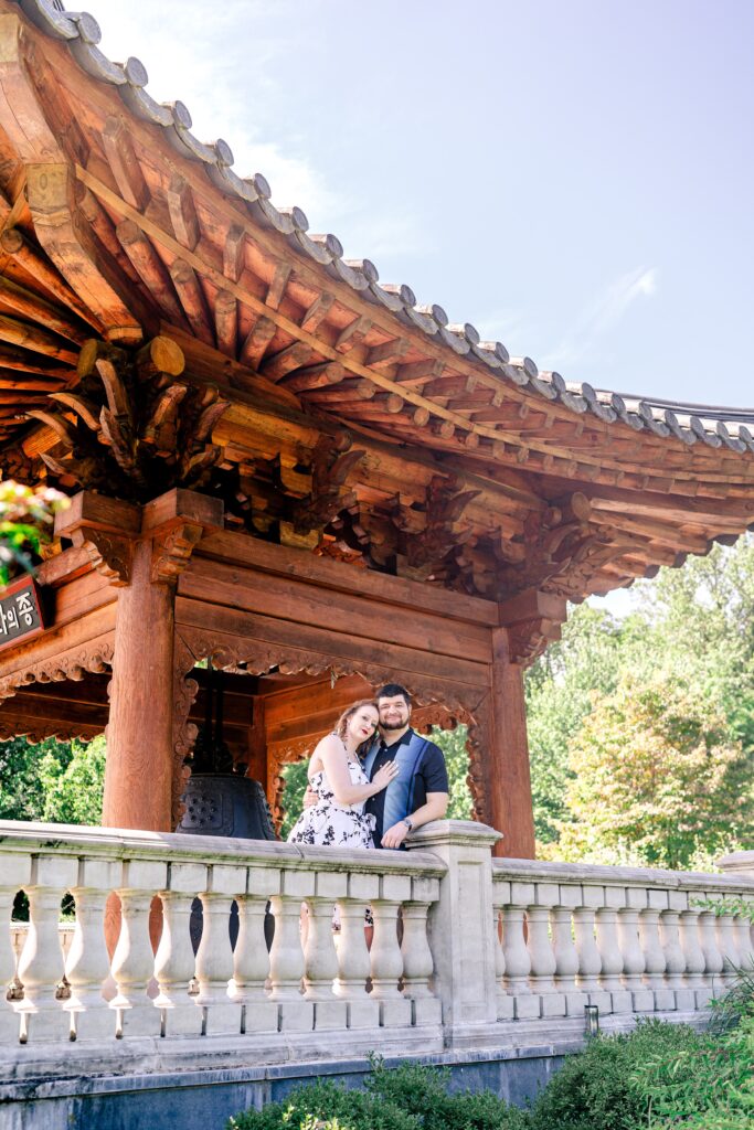 A couple posed in front of a Korean gazebo at the best place to take engagement photos near DC