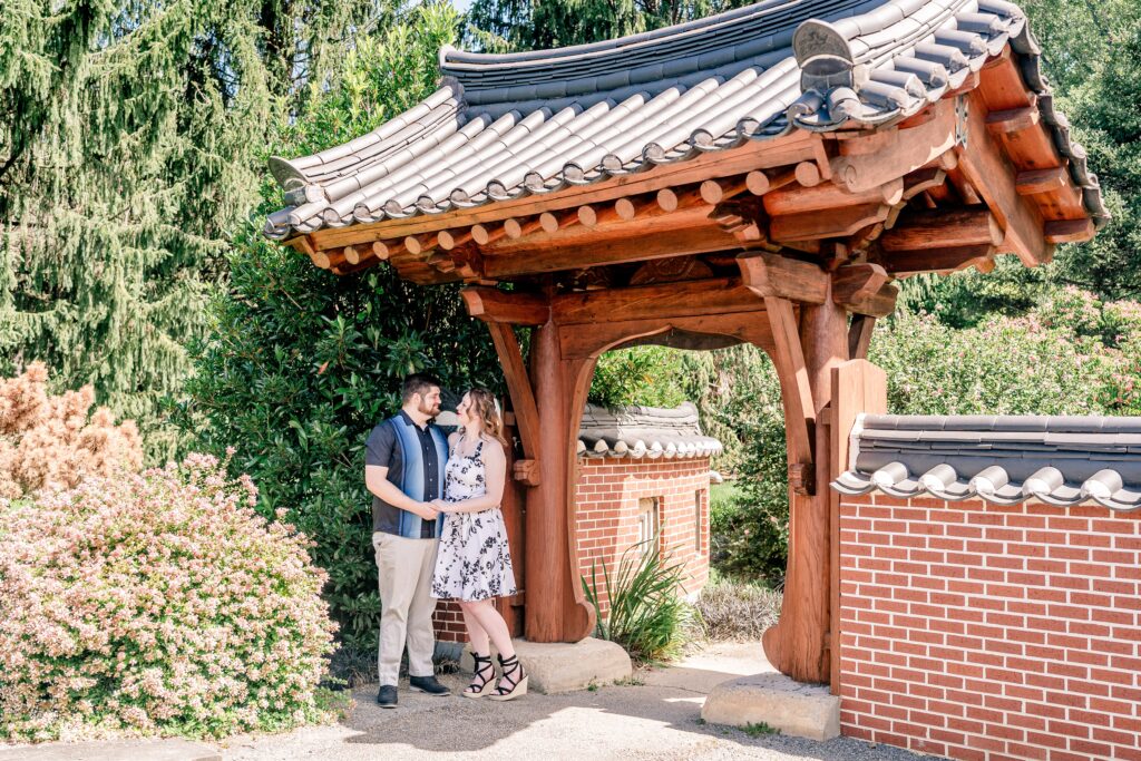 An engaged couple holding hands and smiling at one another for Meadowlark Botanical Gardens engagement photos