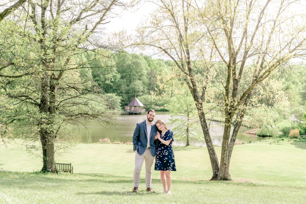 A couple posing close to one another smiling at the camera on a sunny day for their Meadowlark Botanical Gardens engagement photos
