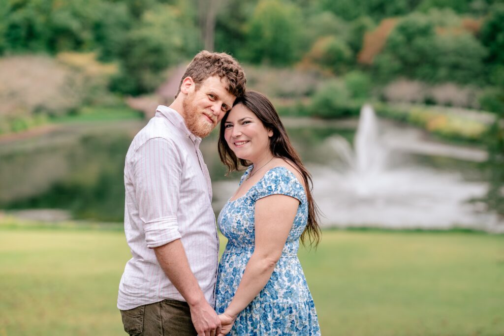 An engaged couple holding hands and smiling at the camera for their Meadowlark Botanical Gardens engagement photos