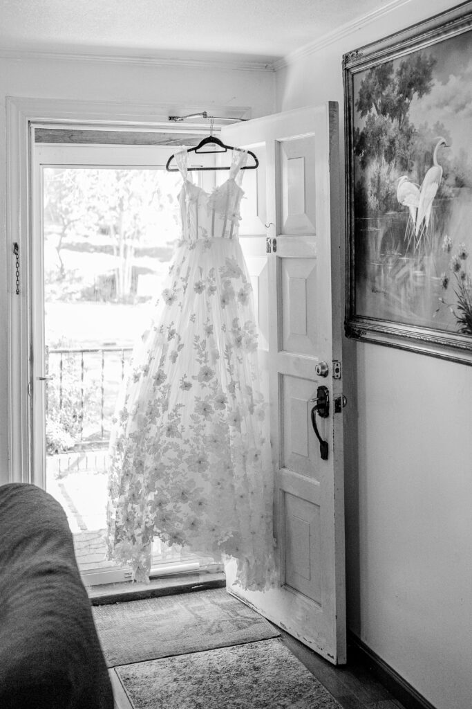 A wedding dress hanging in the doorway of a home