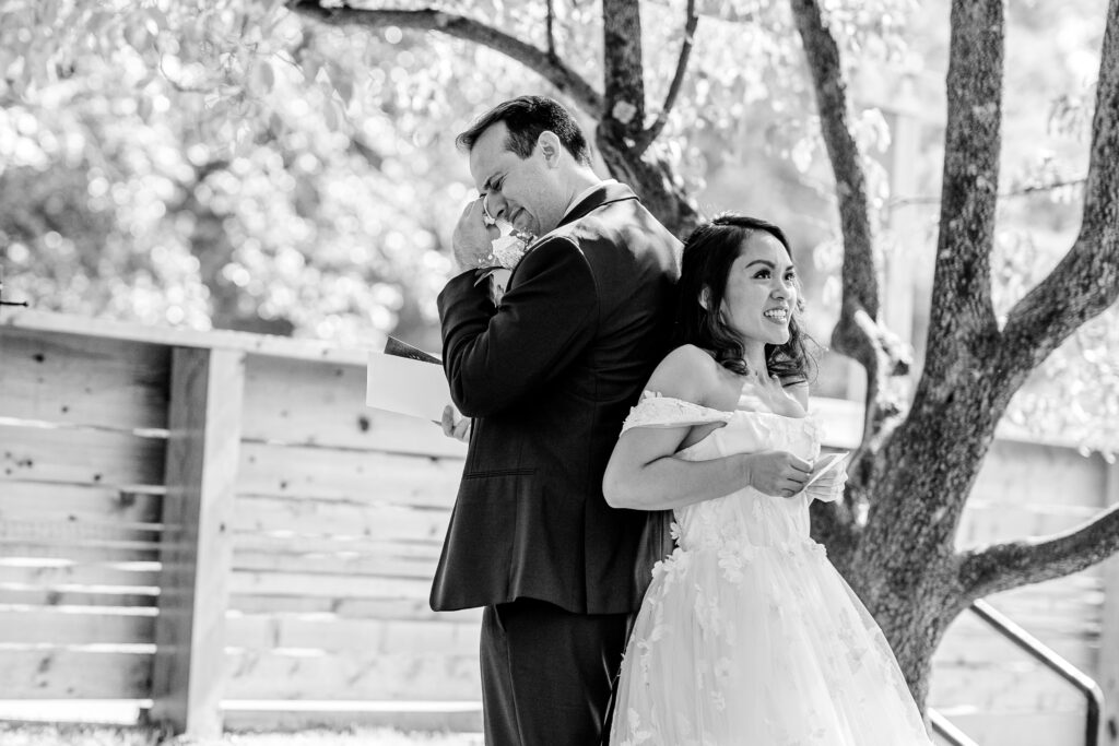 A groom wiping tears as he prays with his bride before their ceremony during a Murray Hill wedding