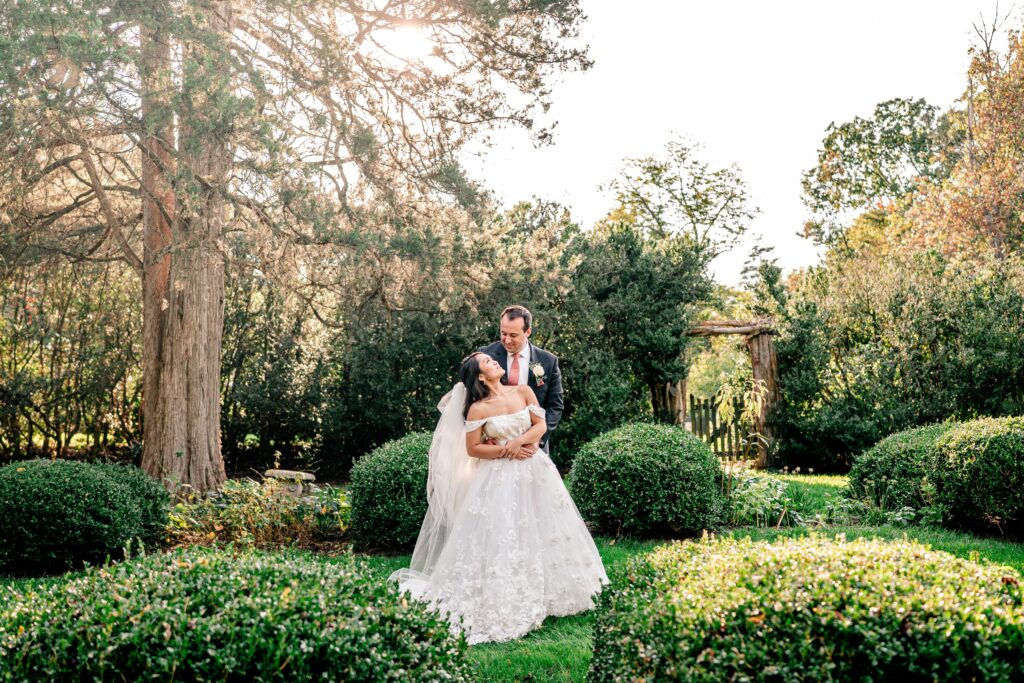 A bride and groom share a sweet moment in the garden at golden hour