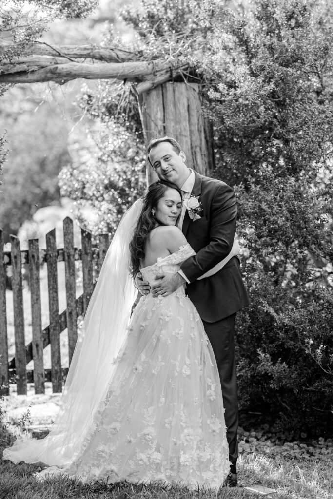 A bride and groom embrace in the garden