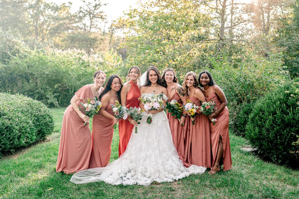 A bride and her bridesmaids pose in the garden for a Murray Hill wedding