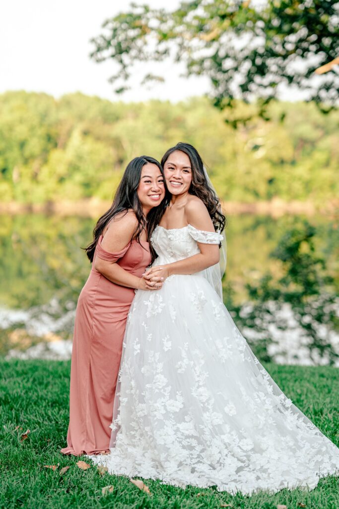 A bride and her bridesmaid posing for a classic portrait after a St. John the Beloved wedding