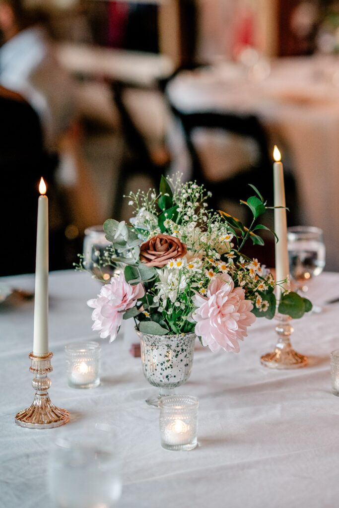 Pink and brown flowers on a reception table after a St. John the Beloved wedding