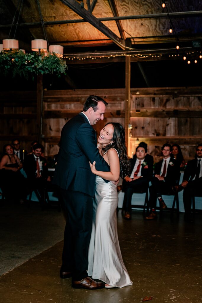 A bride and groom laughing together on the dance floor during their Murray Hill wedding reception