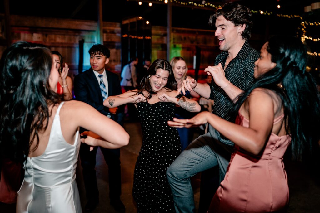 Wedding guests dancing together at a barn wedding reception