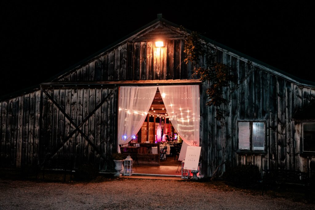A view of a Murray Hill wedding reception in the barn from outside at night