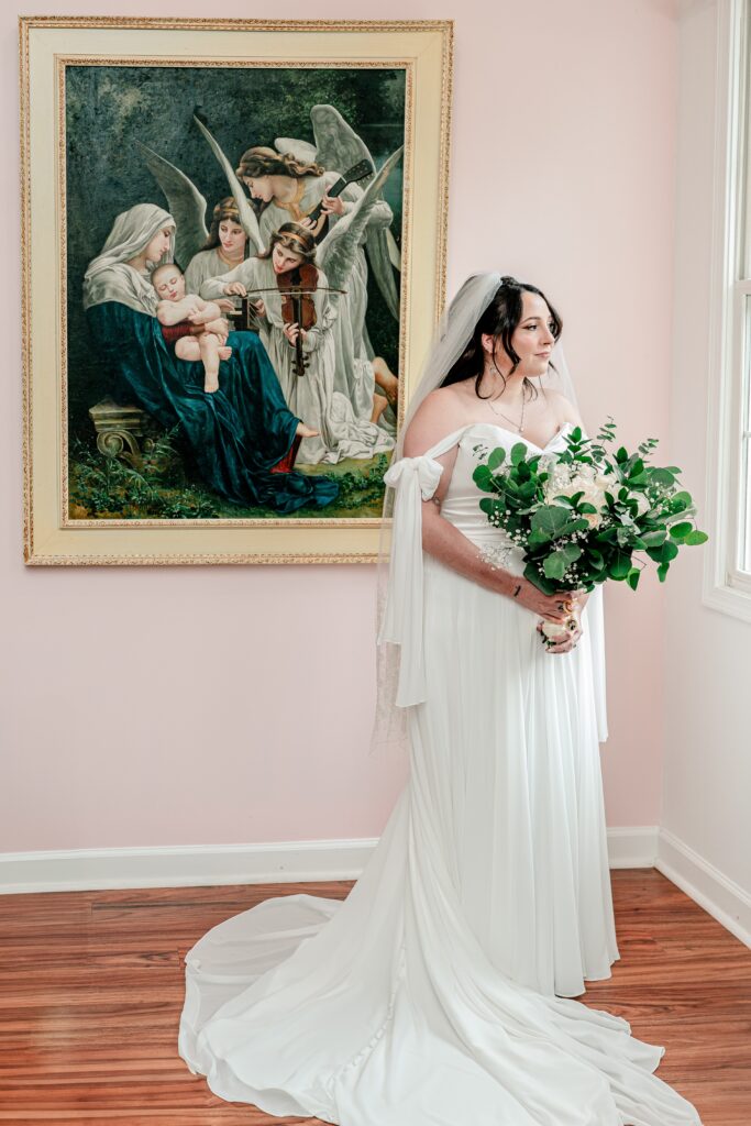 A bride gazing out the window after getting ready in the bridal suite for her Stone Manor Boutique Inn wedding