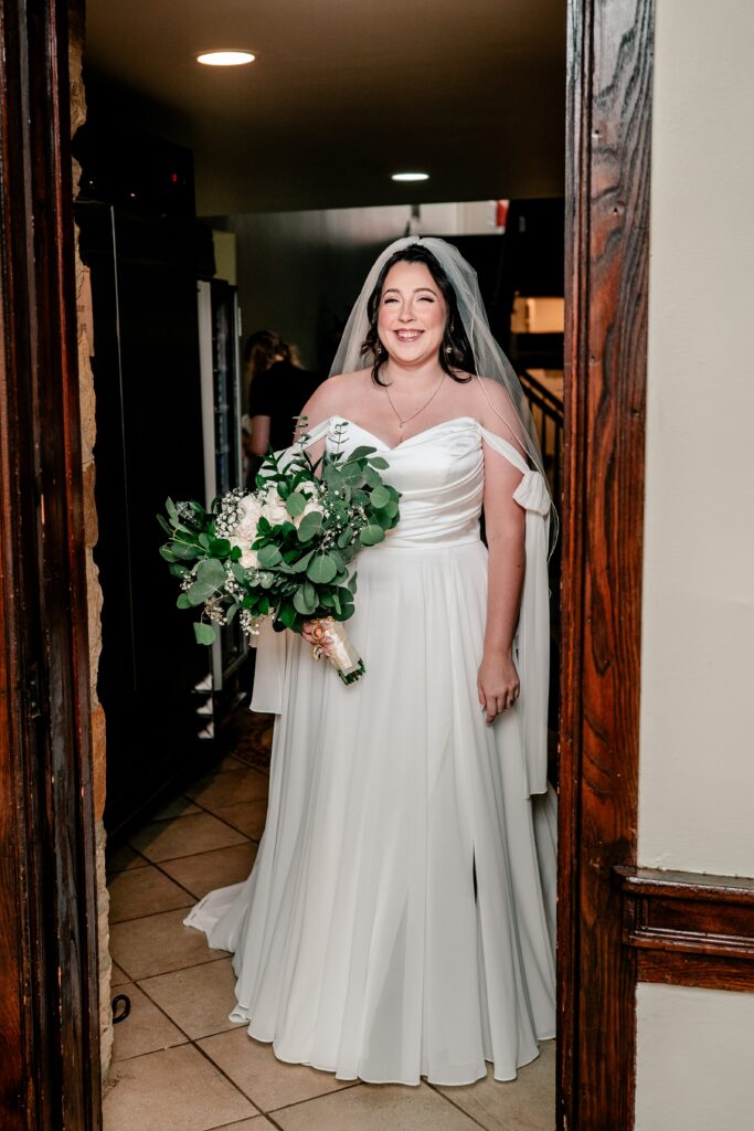 A bride smiling before her first look during a Stone Manor Boutique Inn wedding