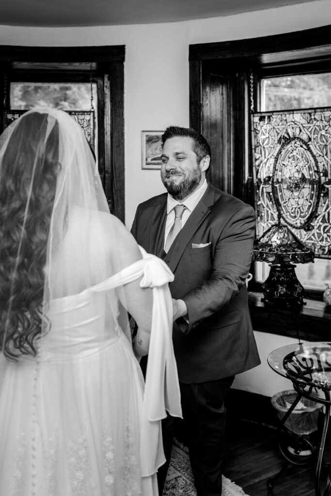 A groom smiling at his bride during their first look with a Northern VA wedding photographer