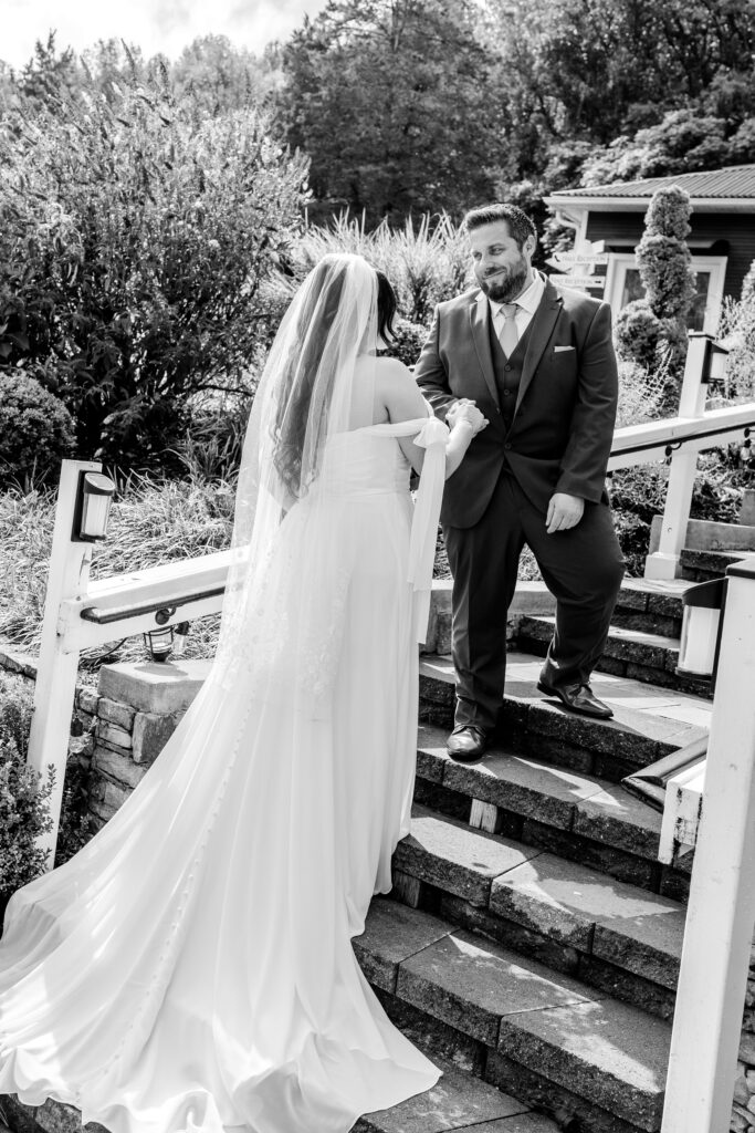 A groom helping his bride up the stairs with their Northern VA wedding photographer
