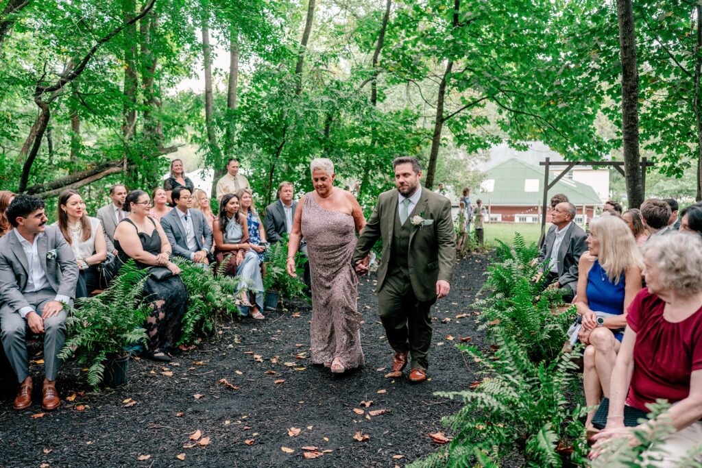 A groom and his mom entering the wedding ceremony