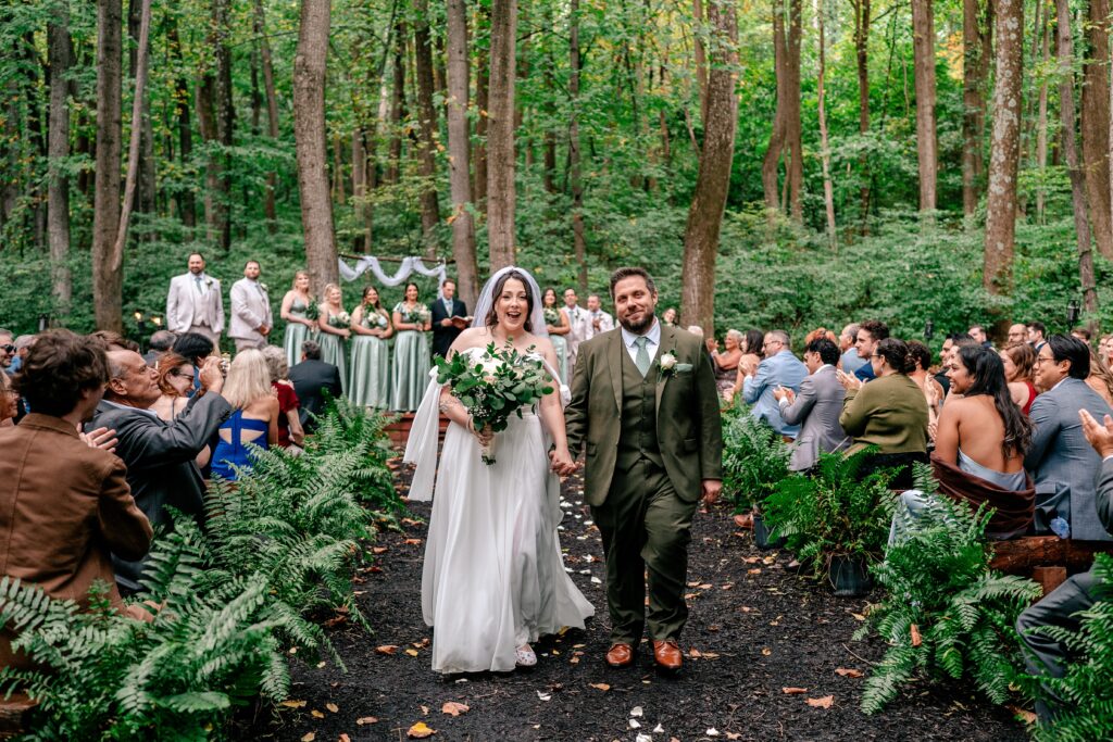 A bride and groom smiling as they exit their Stone Manor Boutique Inn wedding