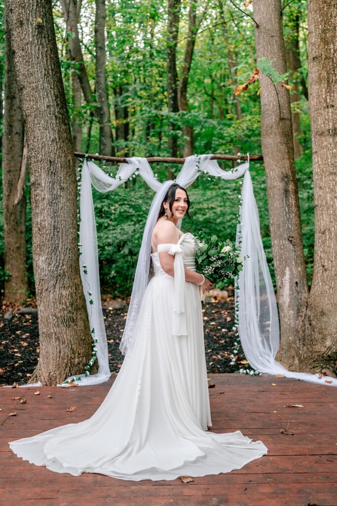 A bride posed in front of her ceremony arch for a Loudoun County wedding
