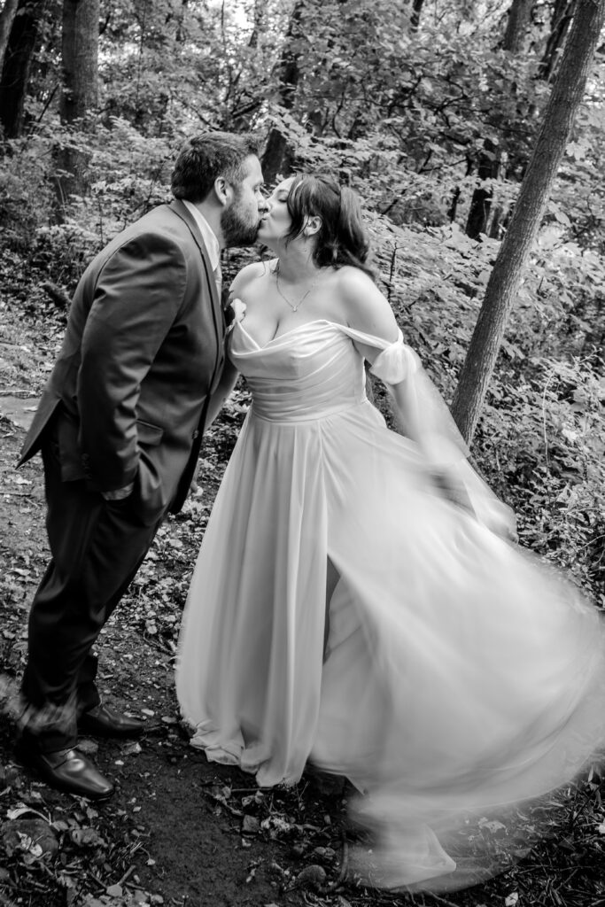 A bride and groom share a kiss as she swishes her skirt with motion blur