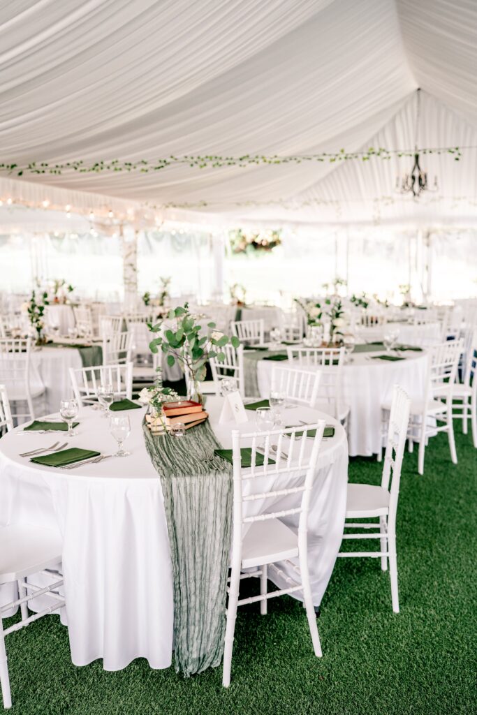 A tented wedding reception with green decor