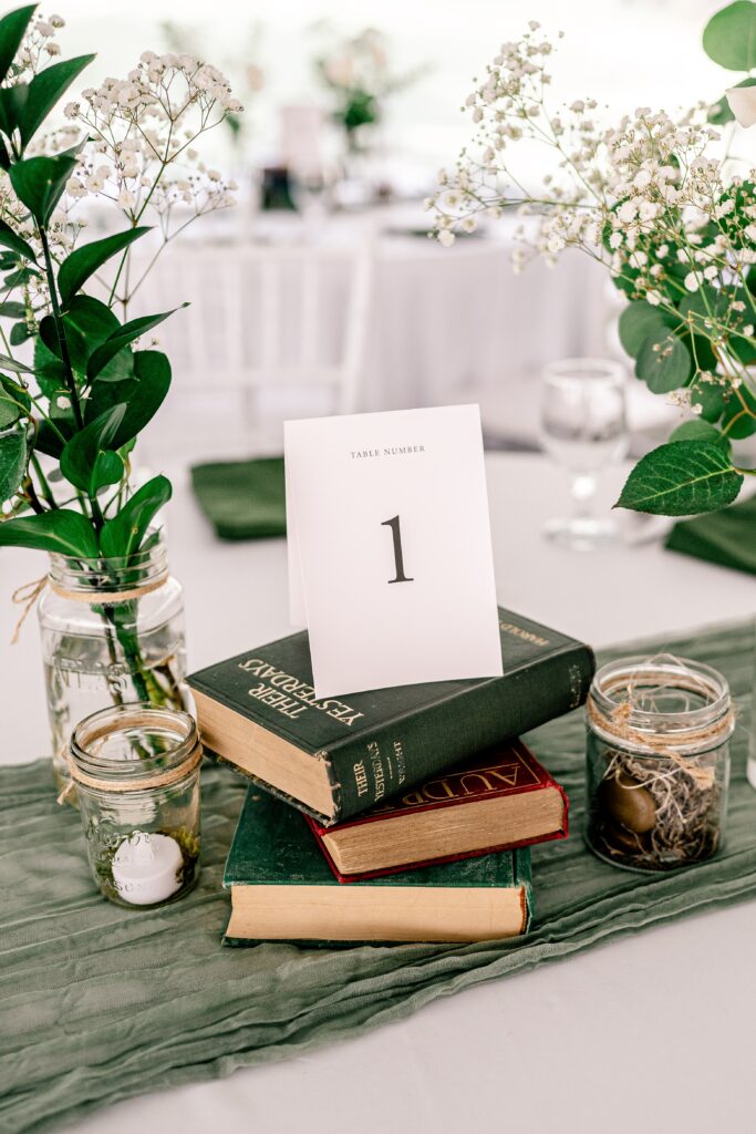 A reception table centerpiece featuring vintage books and flowers during a Loudoun County wedding