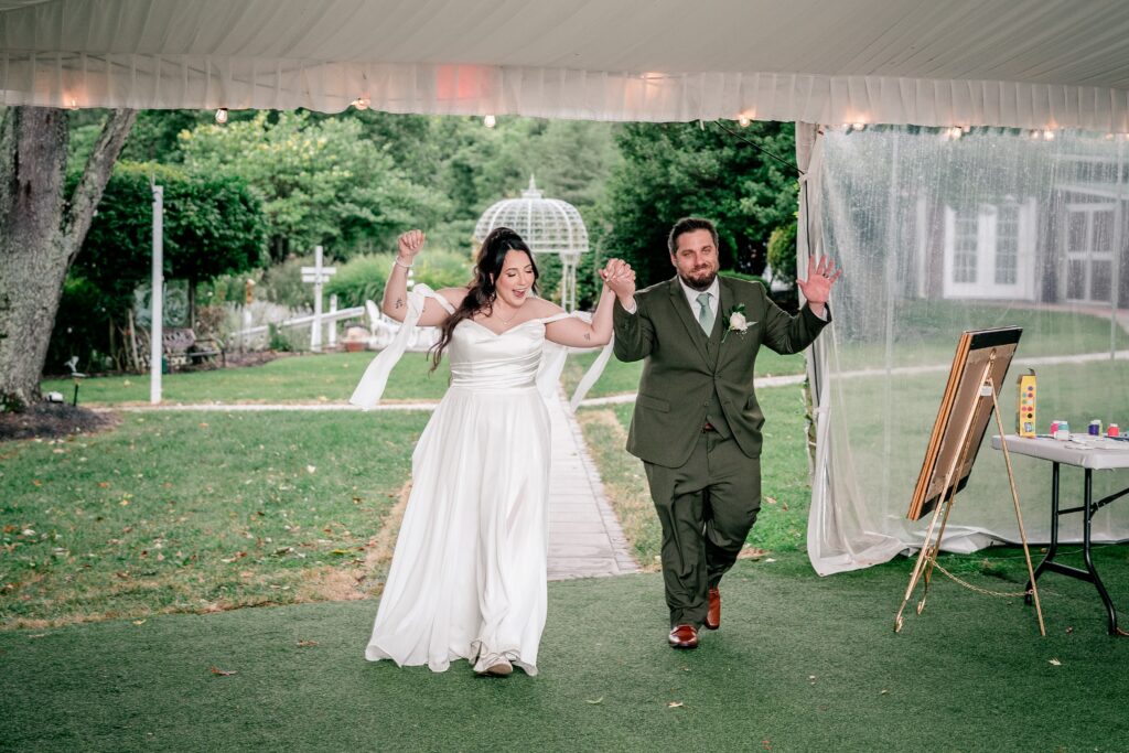 A bride and groom smiling as they enter their wedding reception
