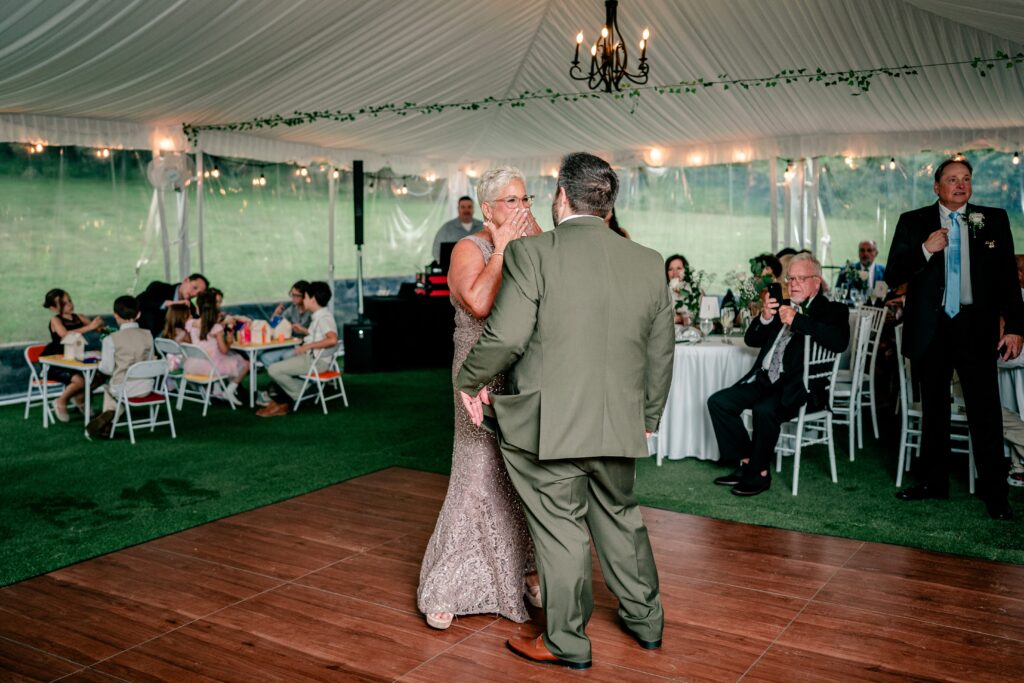 The mother of the groom excited to dance with her son during his Stone Manor Boutique Inn wedding