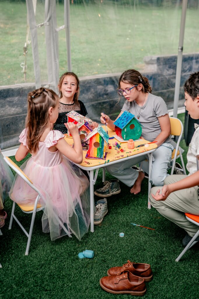 A Northern VA wedding photographer captures kids painting bird houses during a reception