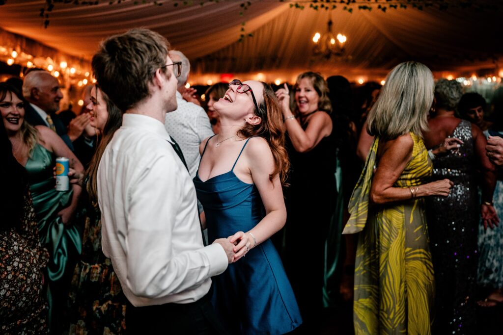 A Northern VA wedding photographer image of guests dancing during a tented reception