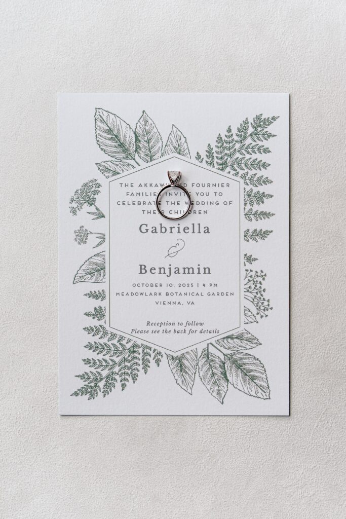 An invitation and engagement ring before a Meadowlark Botanical Gardens wedding