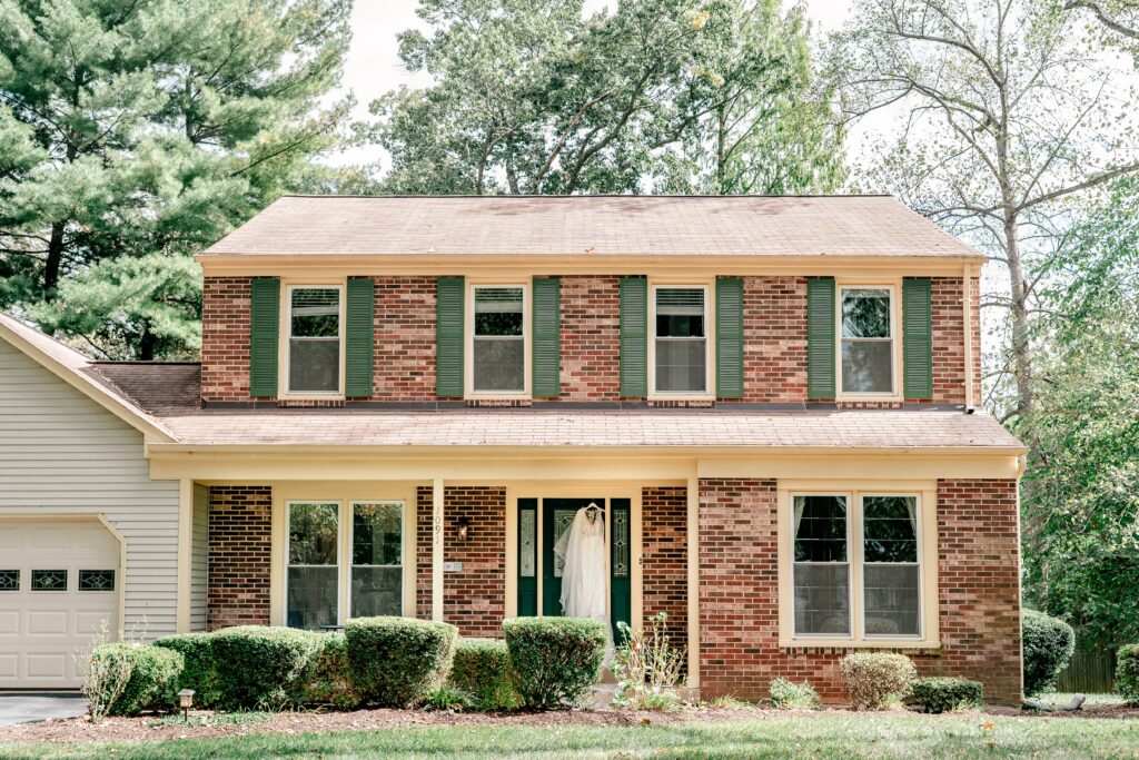 A wedding dress hanging in the front door of the bride's childhood home
