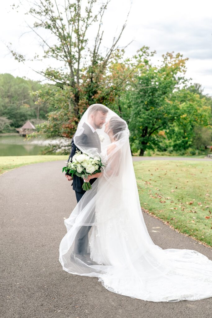 A bride and groom under the veil as it blows in the breeze for a Meadowlark Botanical Gardens wedding