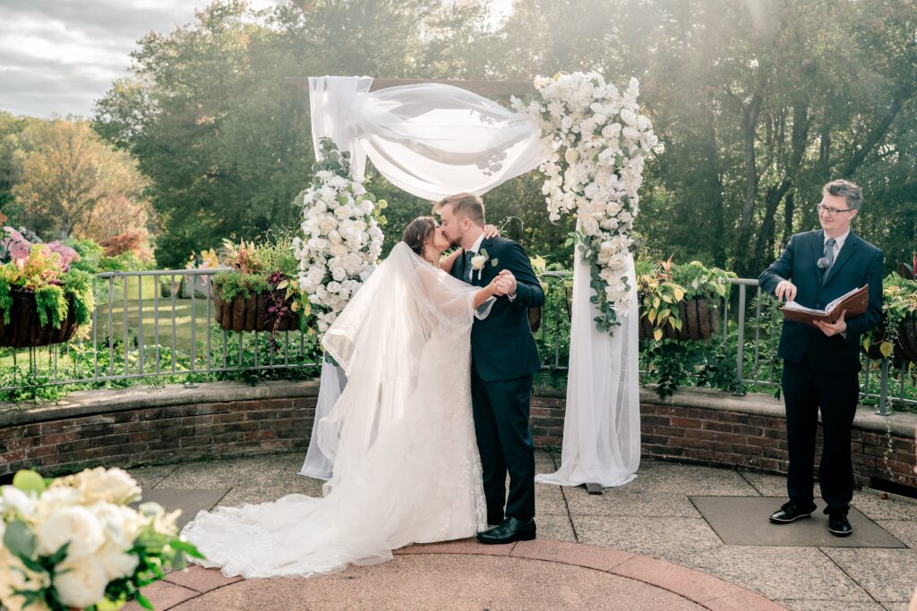 A bride and groom share their big kiss at the end of their Meadowlark Botanical Gardens wedding ceremony