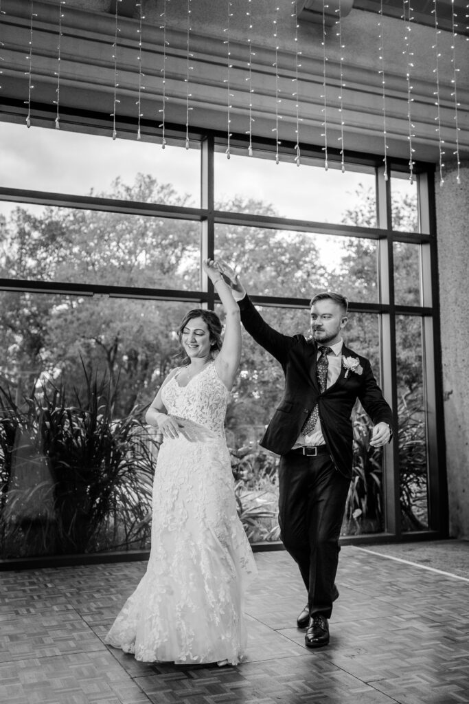 A bride and groom twirl on the dance floor during their Atrium at Meadowlark wedding reception