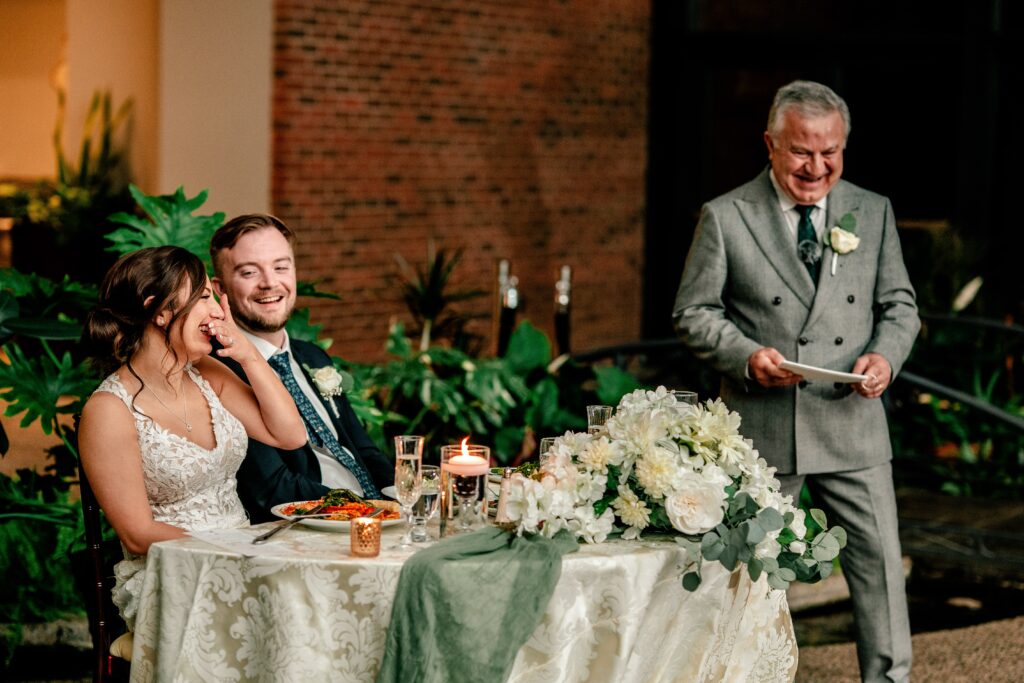 During an Atrium at Meadowlark wedding, the bride and groom laugh at a toast