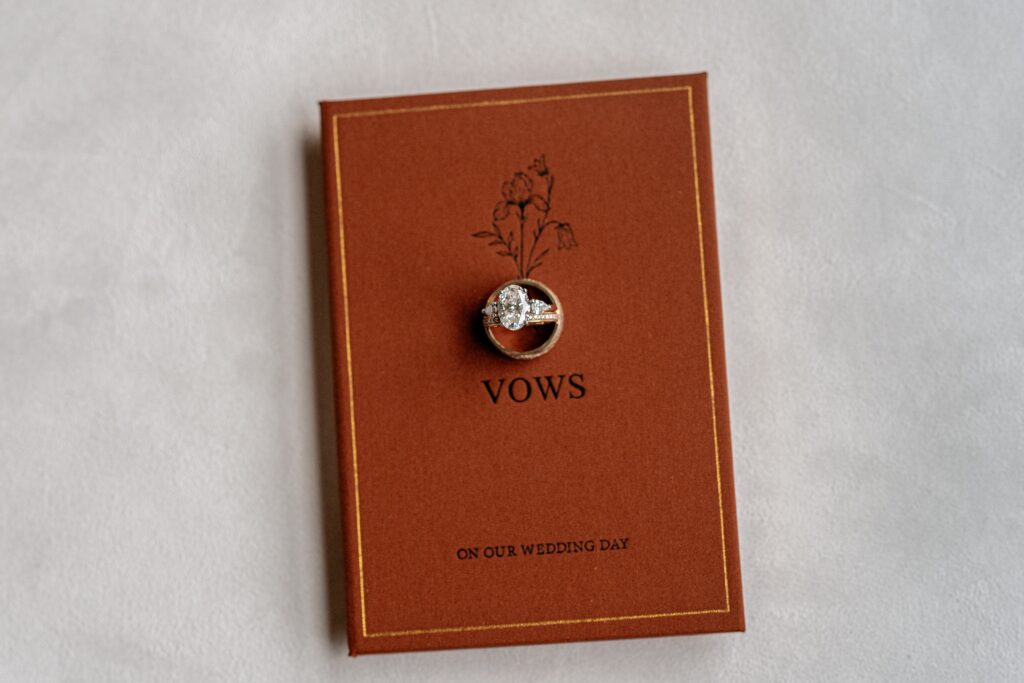 Rings resting on top of a vow book styled by a Northern VA wedding photographer