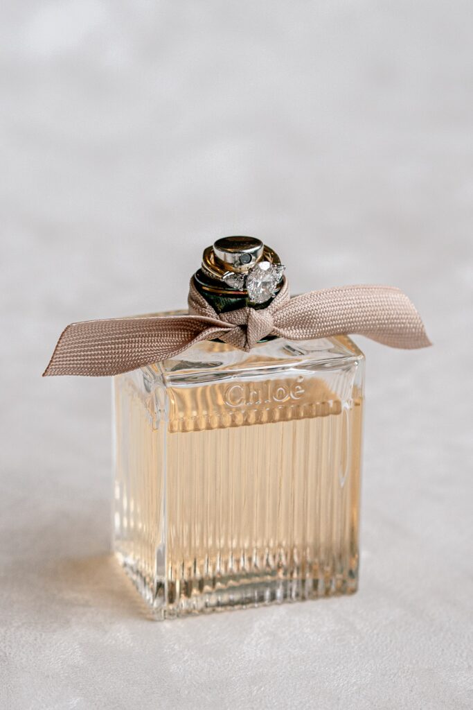A perfume bottle with the bride's ring resting on it before a Meadowlark Botanical Gardens fall wedding