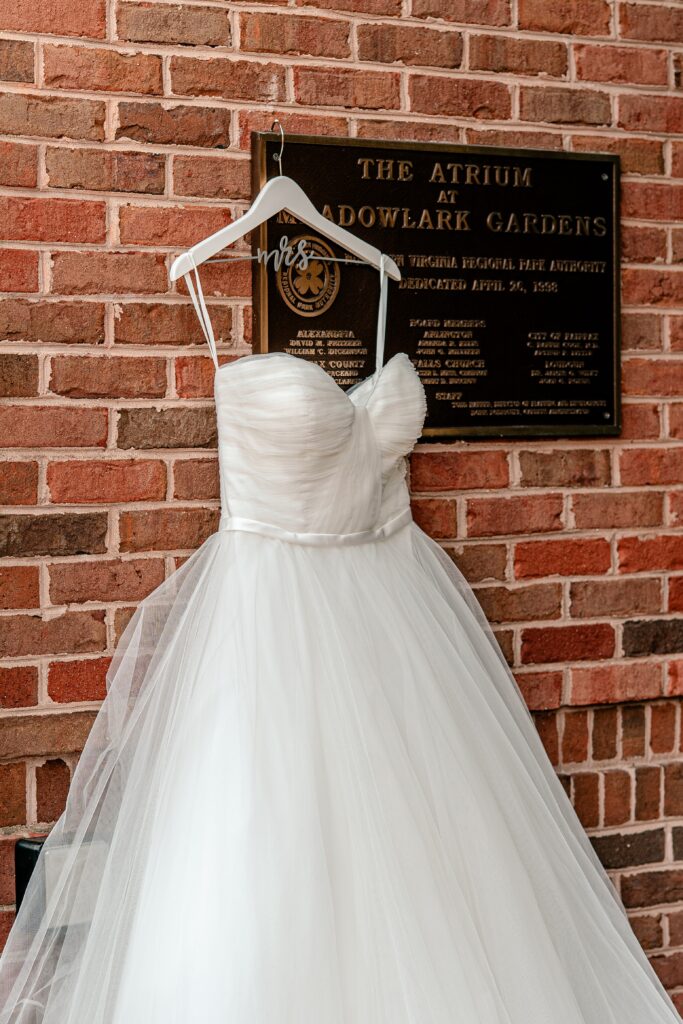A wedding dress hanging by the entrance for a Meadowlark Botanical Gardens fall wedding