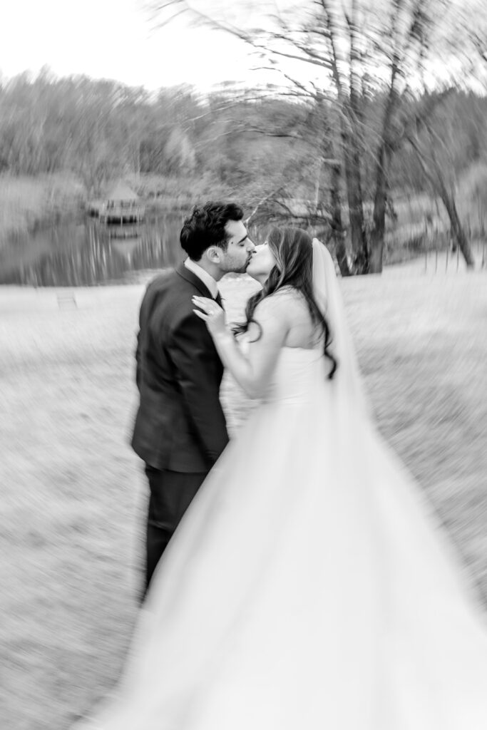 A bride and groom pose for portraits on the lawn before their Atrium at Meadowlark indoor wedding