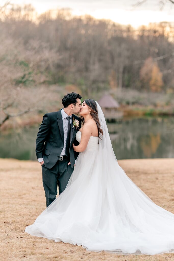 A bride and groom sharing a kiss during golden hour portraits