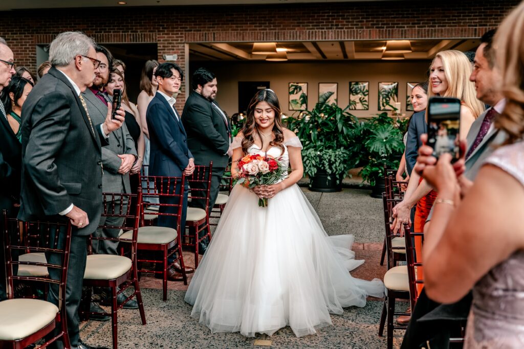 A bride walking down the aisle for her Atrium at Meadowlark indoor wedding