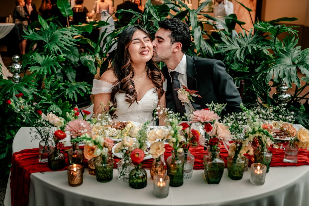 A bride and groom at their sweetheart table during their Meadowlark Botanical Gardens fall wedding