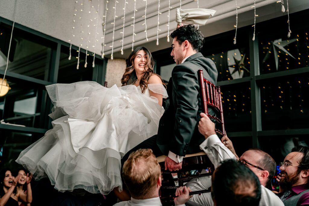 A bride and groom smiling during the hora photographed by their Northern VA wedding photographer
