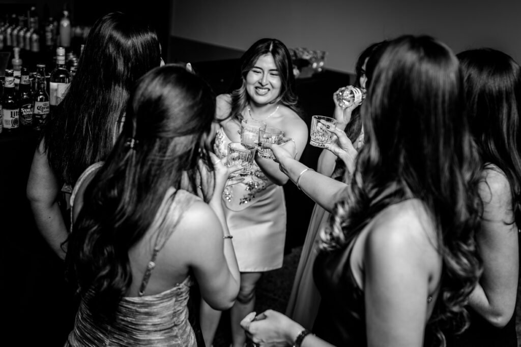 A bride and her friends toast together during the reception in a moment captured by her Northern VA wedding photographer