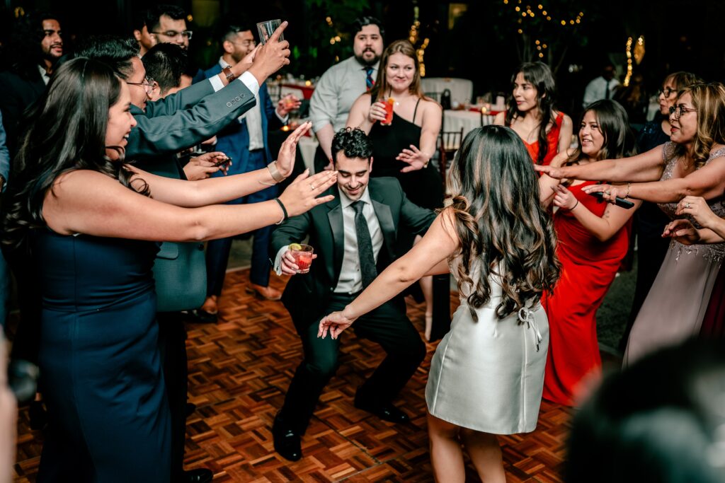 A bride and groom dancing surrounded by guests during their Atrium at Meadowlark indoor wedding reception