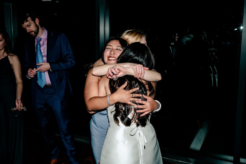 A bride hugging her friends during her Meadowlark Botanical Gardens fall wedding reception