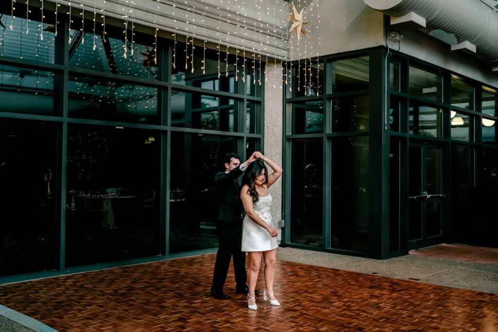 A groom twirls his bride during their private last dance