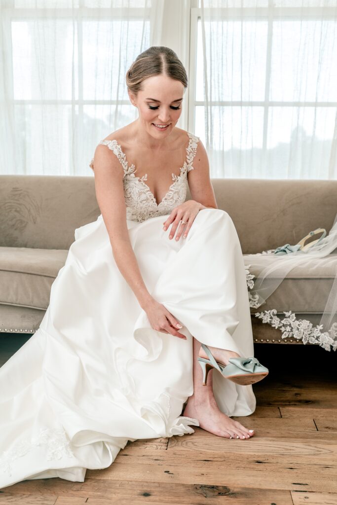 A bride getting ready putting on her shoes before her The Estate at Independence wedding