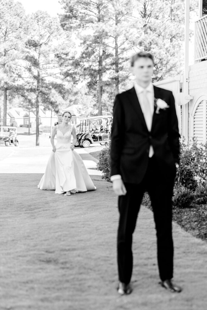 A bride approaching her groom during their first look at a The Estate at Independence wedding